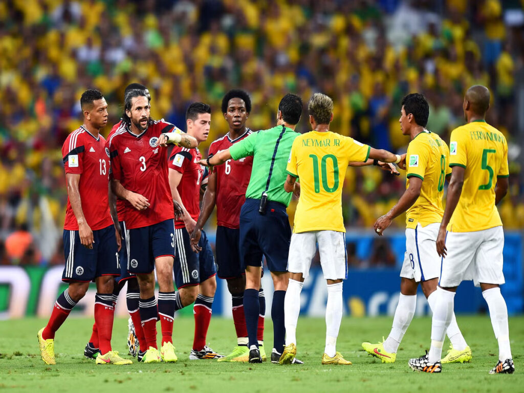 Brazil and Colombia players help each other up after a collision